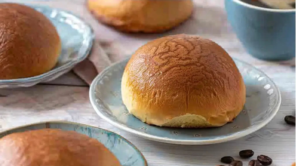 Freshly baked Papparoti buns with crispy coffee topping and melted butter, served with a cup of coffee.