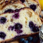 How to Make the Best Lemon Blueberry Sourdough Bread at Home 15 Lemon blueberry sourdough bread sliced on a cutting board with whipped blueberry butter